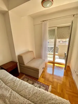 a room with two beds and a couch and a window at Danilo's apartment in Podgorica