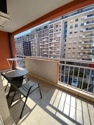 a balcony with a table and chairs and a large building at Danilo's apartment in Podgorica