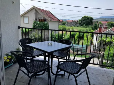 a table and chairs on a balcony with a view at Peaceful 2BR Apt with Ultra-Fast WiFi in Podgorica