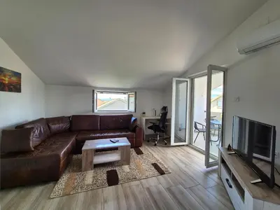 a living room with a brown leather couch and a television at Peaceful 2BR Apt with Ultra-Fast WiFi in Podgorica
