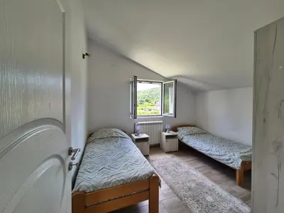 a small room with two beds and a window at Peaceful 2BR Apt with Ultra-Fast WiFi in Podgorica