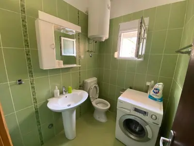 a green bathroom with a sink and a washing machine at Apartments Marilu in Kotor