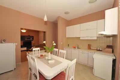 a kitchen and dining room with a white table and chairs at Apartments Marilu in Kotor