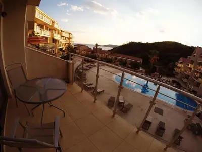 a balcony with a table and a view of a pool at Montetrest Apartments in Sveti Stefan
