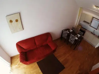 a living room with a red chair and a table at Montetrest Apartments in Sveti Stefan