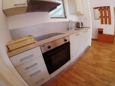 a kitchen with white cabinets and a stove top oven at Montetrest Apartments in Sveti Stefan
