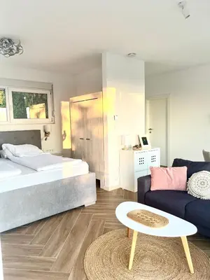 a bedroom with a bed and a couch and a table at Bungalow for 2 - Dream Oasis Dobra Voda in Dobra Voda