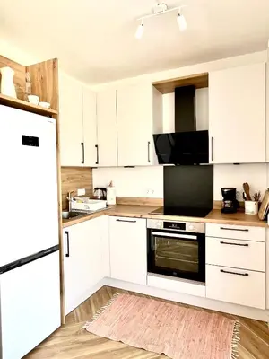 a kitchen with white cabinets and a black appliance at Bungalow for 2 - Dream Oasis Dobra Voda in Dobra Voda
