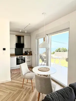 a kitchen and living room with a table and chairs at Bungalow for 2 - Dream Oasis Dobra Voda in Dobra Voda