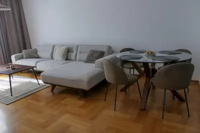 a living room with a couch and a table and chairs at Apartments Radovic in Podgorica