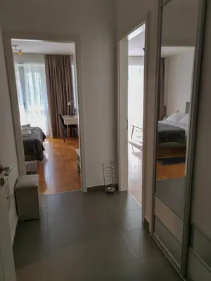 a view of a room with a bedroom and a mirror at Apartments Radovic in Podgorica