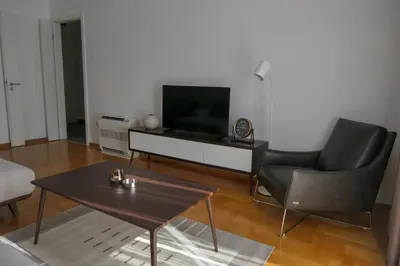 a living room with a television and a table and chairs at Apartments Radovic in Podgorica