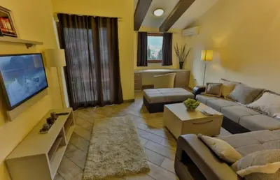 a living room with a couch and a tv at At Oliver’s in Budva