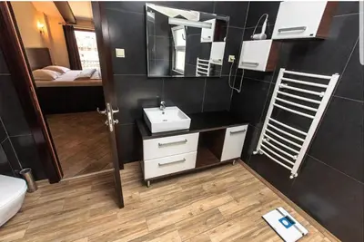 a bathroom with a sink and a mirror and a bed at At Oliver’s in Budva