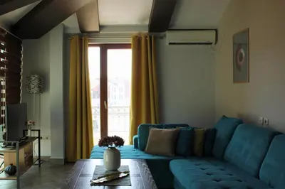 a living room with a blue couch and a window at At Oliver’s in Budva
