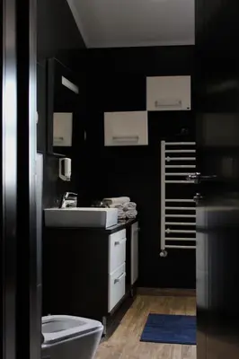 a black bathroom with a toilet and a sink at At Oliver’s in Budva