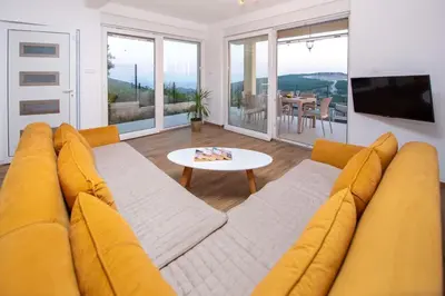 a living room with a yellow couch and a table at Sunset house in Višnjevo