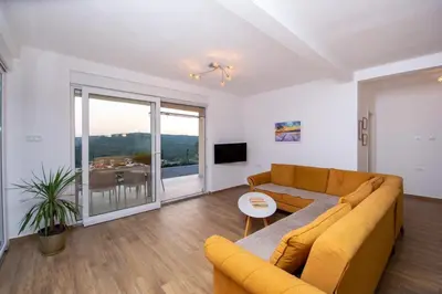 a living room with a couch and a table at Sunset house in Višnjevo