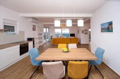 a kitchen and dining room with a wooden table and chairs at Sunset house in Višnjevo