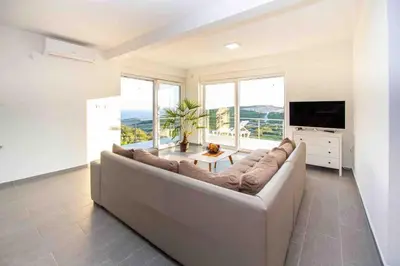 a living room with a large couch and a television at Sunset house in Višnjevo
