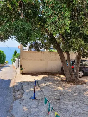 a tree and a car parked next to a building at Stadjorluk Hladna uvala in Kruče
