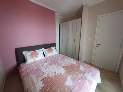 a bedroom with a bed with a pink wall at Stadjorluk Hladna uvala in Kruče