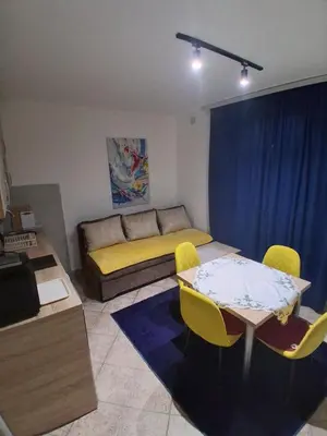 a living room with a bed and a table and chairs at apartman19 in Podgorica