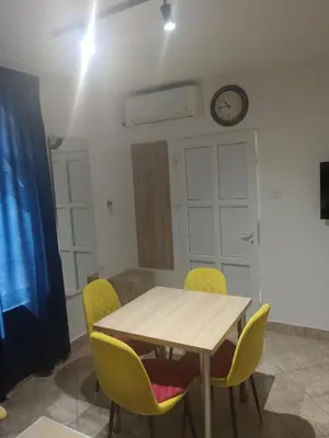 a dining room with a table and yellow chairs at apartman19 in Podgorica