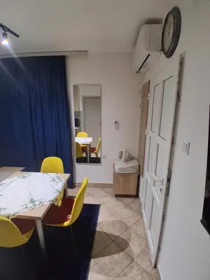 a room with a table and chairs and a clock on the wall at apartman19 in Podgorica
