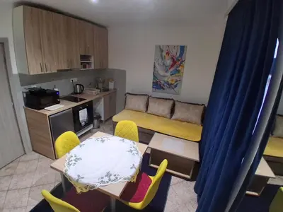a kitchen and a living room with a table and chairs at apartman19 in Podgorica