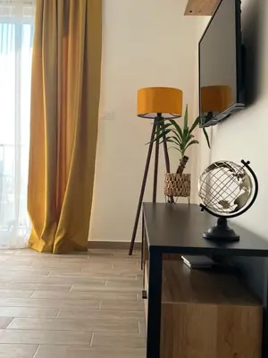 a room with a table with a lamp and a mirror at Apartments HAS in Kotor