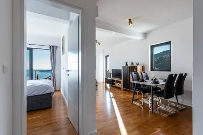 a bedroom and a dining room with a bed and a table at Olive Tree Apartments in Becici
