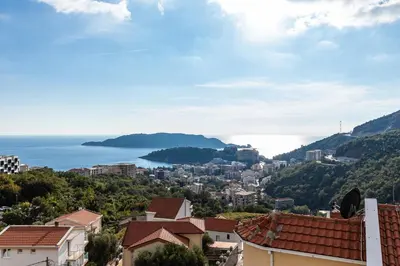 a view of a city with the ocean in the background at Olive Tree Apartments in Becici