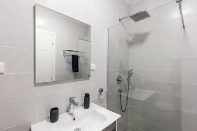 a white bathroom with a sink and a shower at Olive Tree Apartments in Becici