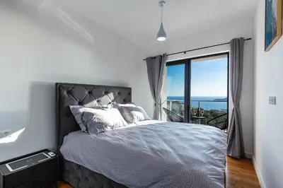 a bedroom with a bed and a large window at Olive Tree Apartments in Becici