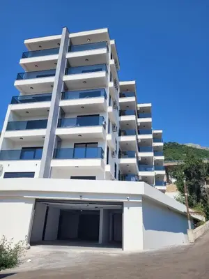 a large white apartment building with a parking lot at SD LUX APARTMENTS in Dobra Voda
