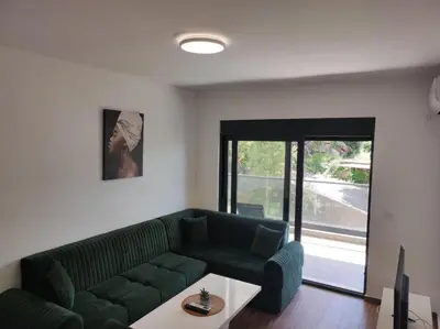 a living room with a green couch and a table at SD LUX APARTMENTS in Dobra Voda