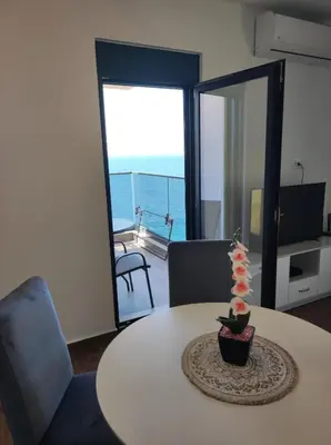 a room with a table with a view of the ocean at SD LUX APARTMENTS in Dobra Voda