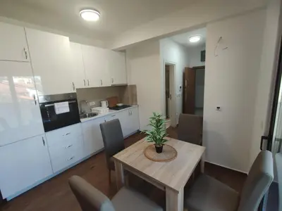 a kitchen and dining room with a table and chairs at SD LUX APARTMENTS in Dobra Voda