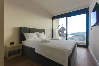 a bedroom with a large bed with a large window at Elia Suites in Becici