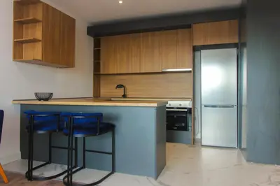 a kitchen with a counter and blue stools in it at Elia Suites in Becici