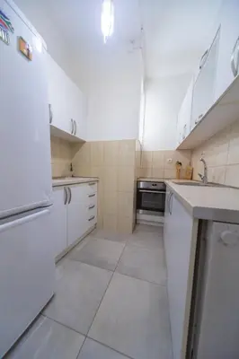 a white kitchen with white cabinets and a dishwasher at center_apartment_LUX in Podgorica