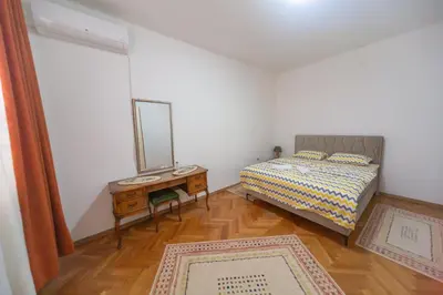 a bedroom with a bed and a mirror and a table at center_apartment_LUX in Podgorica