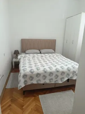 a bedroom with a bed in a white room at center_apartment_LUX in Podgorica