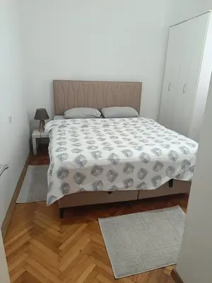 a bedroom with a bed with a comforter on it at center_apartment_LUX in Podgorica