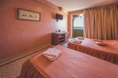a hotel room with two beds and a window at Villa Barcelona in Sutomore