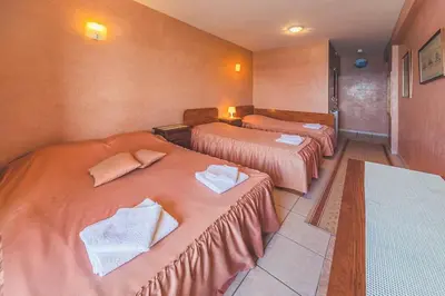 a hotel room with three beds with towels on them at Villa Barcelona in Sutomore