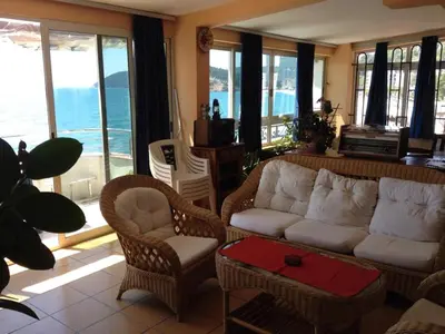 a living room with a couch and chairs and windows at Villa Barcelona in Sutomore