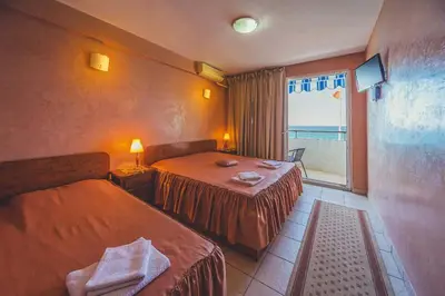 a hotel room with two beds and a window at Villa Barcelona in Sutomore