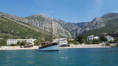 a boat sitting in the water next to a beach at Villa Barcelona in Sutomore
